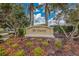 Welcoming entrance sign to The Enclave at the Villages of Pinetree surrounded by lush landscaping and swaying palm trees at 1814 Pinyon Pine Dr, Sarasota, FL 34240