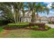 Well-manicured front yard with mature landscaping and a three car garage at 1814 Pinyon Pine Dr, Sarasota, FL 34240