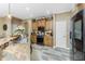 A kitchen featuring granite countertops, a stainless steel sink, wood cabinets, and tile flooring at 1814 Pinyon Pine Dr, Sarasota, FL 34240