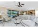 A spacious living room with a ceiling fan and sliding glass doors that lead to the lanai and pool at 1814 Pinyon Pine Dr, Sarasota, FL 34240