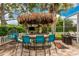 Spacious outdoor patio with a tiki bar, outdoor seating, grill, and lush landscaping at 1814 Pinyon Pine Dr, Sarasota, FL 34240