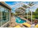 A covered pool and patio area with lounge chairs and access to the interior of the home at 1814 Pinyon Pine Dr, Sarasota, FL 34240