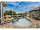 A covered pool and patio area with a spa and lounge chairs at 1814 Pinyon Pine Dr, Sarasota, FL 34240