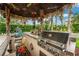 Stainless steel gas grill and built-in bar with floral outdoor rug and backyard views at 1814 Pinyon Pine Dr, Sarasota, FL 34240