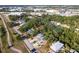 Aerial view of a home surrounded by trees in a suburban area with commercial centers in the distance at 1851 Scenic Dr, Venice, FL 34293