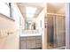 Well-lit bathroom featuring a vanity with ample storage and a glass-enclosed shower at 1851 Scenic Dr, Venice, FL 34293