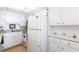 Bright kitchen with white cabinets, appliances, and a double basin sink at 1851 Scenic Dr, Venice, FL 34293