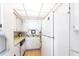 Bright kitchen featuring white appliances and cabinets and a double basin sink at 1851 Scenic Dr, Venice, FL 34293