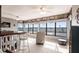 Spacious sunroom featuring waterfront views, comfortable seating, a bar area, and maritime décor at 1851 Scenic Dr, Venice, FL 34293