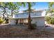 Back exterior view showcasing a home with a patio accessible via sliding glass doors and a gravel ground cover at 1851 Scenic Dr, Venice, FL 34293