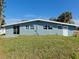 Exterior rear view of the home, features a grassy lawn and a sliding glass door at 190 Danforth Dr, Punta Gorda, FL 33980