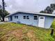 Exterior rear view of the home, features a grassy lawn and a sliding glass door at 190 Danforth Dr, Punta Gorda, FL 33980