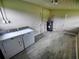 A view of the laundry room shows a washer, dryer, and water heater on gray flooring at 190 Danforth Dr, Punta Gorda, FL 33980
