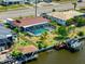 Aerial view highlighting a waterfront property with a private pool, lush yard, and dock at 21169 Edgewater Dr, Port Charlotte, FL 33952