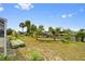 Spacious backyard featuring a canal view, mature trees, and ample room for outdoor activities at 21169 Edgewater Dr, Port Charlotte, FL 33952