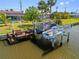 Dock with boat lift situated on the water, perfect for boating and fishing enthusiasts at 21169 Edgewater Dr, Port Charlotte, FL 33952