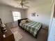 Cozy bedroom featuring a comfortable bed with a green patterned coverlet, a ceiling fan, and neutral walls at 21342 Walling Ct, Port Charlotte, FL 33954