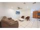 Cozy living room with tile floors, ceiling fan, and a view into the kitchen at 2230 Harbor Blvd, Port Charlotte, FL 33952