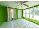 Bright sunroom with tile floor, ceiling fan, and many windows offering natural light at 2230 Harbor Blvd, Port Charlotte, FL 33952