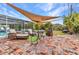 Well-designed backyard with brick patio, shade sails, outdoor furniture, and manicured lawn at 2236 Arnet St, Port Charlotte, FL 33948