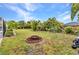 Lush backyard featuring a fire pit, playground, and tropical landscaping at 2236 Arnet St, Port Charlotte, FL 33948