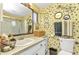 Bathroom showcasing patterned wallpaper, a vanity with sink, and a glass-enclosed shower at 2236 Arnet St, Port Charlotte, FL 33948
