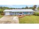 A beautiful, single-story home featuring a lush green lawn, gravel garden, freshly painted exterior and long driveway at 2236 Arnet St, Port Charlotte, FL 33948