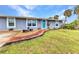 Beautifully landscaped front yard features a brick walkway leading to a charming home entrance with a vibrant blue door at 2236 Arnet St, Port Charlotte, FL 33948