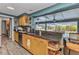 Bright kitchen boasts wood cabinets, granite counters, tile backsplash, and pass-through window to the screened-in pool at 2236 Arnet St, Port Charlotte, FL 33948