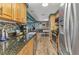 Bright kitchen showcasing stainless steel appliances, wood cabinets, granite counters, and access to the dining area at 2236 Arnet St, Port Charlotte, FL 33948