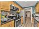 Charming kitchen featuring stainless steel appliances, wood cabinets, granite counters, and tile backsplash at 2236 Arnet St, Port Charlotte, FL 33948