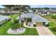 Aerial view of a home with well-manicured landscaping, mature palms, and a brick driveway at 23104 Turnbull Ave, Port Charlotte, FL 33954