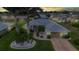 Beautiful single-story home featuring lush landscaping, palm trees, and a brick driveway at 23104 Turnbull Ave, Port Charlotte, FL 33954