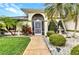 Inviting front entrance with a brick walkway, manicured garden, and a charming fountain at 23104 Turnbull Ave, Port Charlotte, FL 33954
