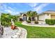 Landscaped front yard features a decorative statue, mature palms, and meticulous landscaping at 23104 Turnbull Ave, Port Charlotte, FL 33954