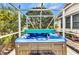 Close-up of an inviting outdoor hot tub inside a screened enclosure with privacy landscaping at 23104 Turnbull Ave, Port Charlotte, FL 33954