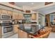 Bright kitchen with island seating, stainless steel appliances and views to the outdoor pool through sliding glass doors at 23104 Turnbull Ave, Port Charlotte, FL 33954