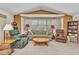 Cozy living room with bay window, recliner and couch with pillows, and an adjacent bookshelf at 23104 Turnbull Ave, Port Charlotte, FL 33954