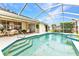 Screened-in pool with patio seating and tropical landscaping provides a relaxing outdoor oasis at 23104 Turnbull Ave, Port Charlotte, FL 33954