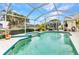 Inviting screened-in pool with a spa and lush landscaping at 23104 Turnbull Ave, Port Charlotte, FL 33954