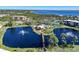 Stunning aerial view of the community, showing lush landscaping, serene ponds with fountains, and the adjacent waterfront at 23465 Harborview Rd # 925, Punta Gorda, FL 33980