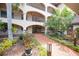 Beautiful courtyard showcasing landscaped flowerbeds, red brick walkways, and views of the building's facade at 23465 Harborview Rd # 925, Punta Gorda, FL 33980
