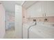 Bright laundry room with washer, dryer, white cabinets, and a doorway leading to another room at 23465 Harborview Rd # 925, Punta Gorda, FL 33980
