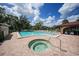 Inviting pool area with a hot tub, lounge chairs, and a clubhouse perfect for relaxation and social gatherings at 23465 Harborview Rd # 925, Punta Gorda, FL 33980