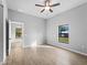 Bedroom with a window letting in sunlight, ceiling fan, and wood-look tile at 2354 Bonanza Ln, North Port, FL 34286