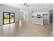 Open-concept living space with tile floors, kitchen with island, and sliding glass doors at 2354 Bonanza Ln, North Port, FL 34286
