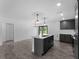 Modern kitchen with an island, stainless steel appliances, and stylish gray cabinets at 2372 Bonanza Ln, North Port, FL 34286