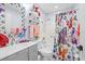 Bathroom with gray vanity, tiled shower, and colorful accents at 25068 Harborview Rd # 1B, Punta Gorda, FL 33980