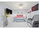 Bedroom with large bed, modern lighting fixture, tile floor and wall-mounted TV at 25068 Harborview Rd # 1B, Punta Gorda, FL 33980