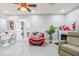 Open living room with tile floors, fireplace, ceiling fan, and adjacent laundry area at 25068 Harborview Rd # 1B, Punta Gorda, FL 33980
